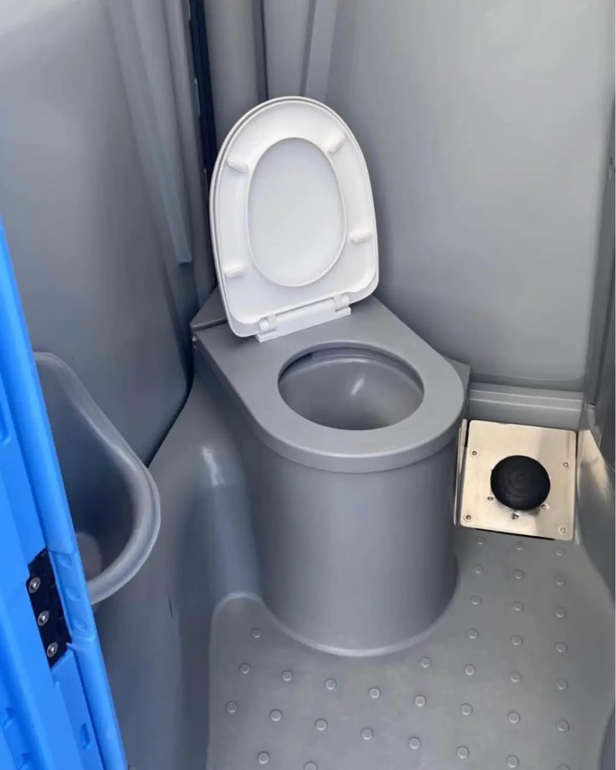 Clean white toilet seat inside a flushing portable toilet
