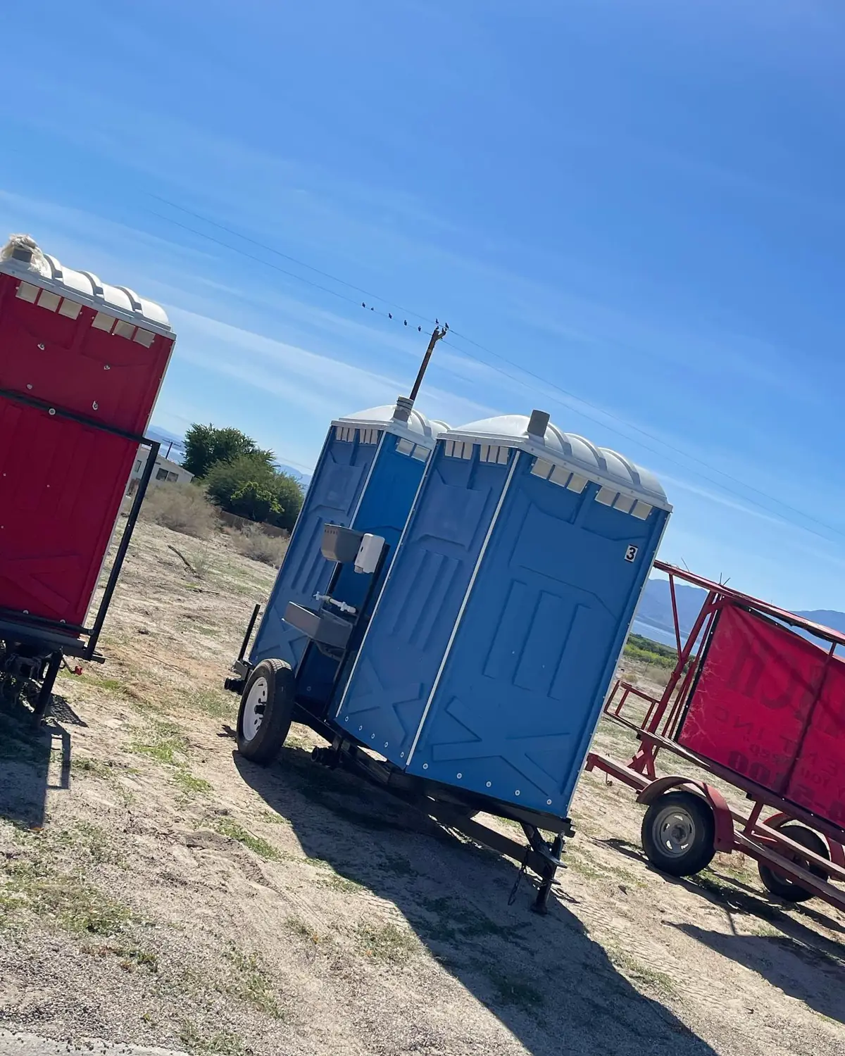 Towable porta potty trailer in a field