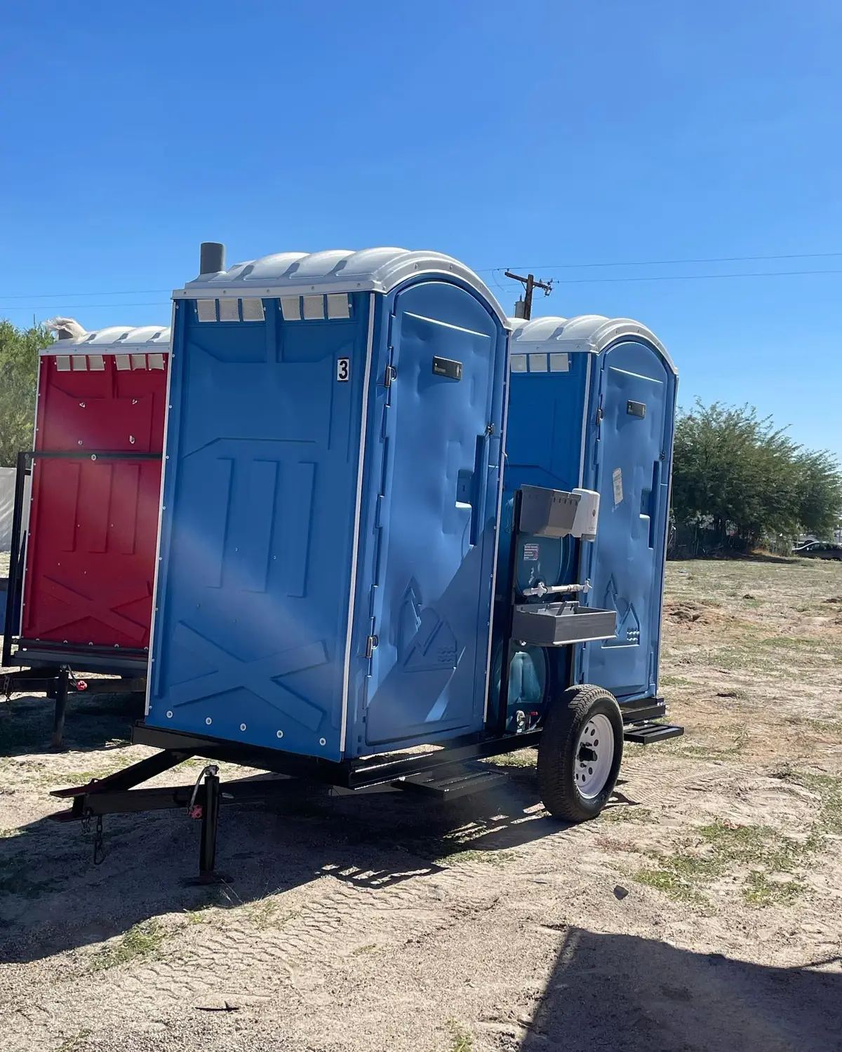 Porta potties mounted on a towable trailer at a dry jobsite