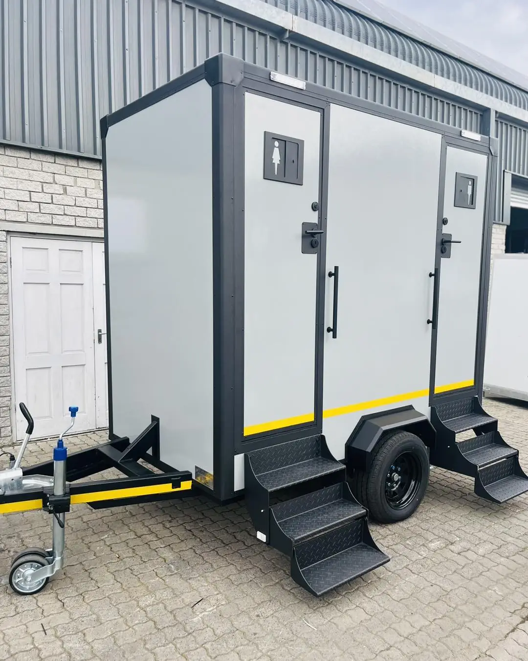 Two-stall restroom trailer with steps at each door